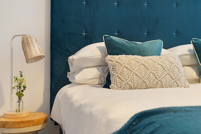 Fluffed pillows and folded duvet styled on a budget bed