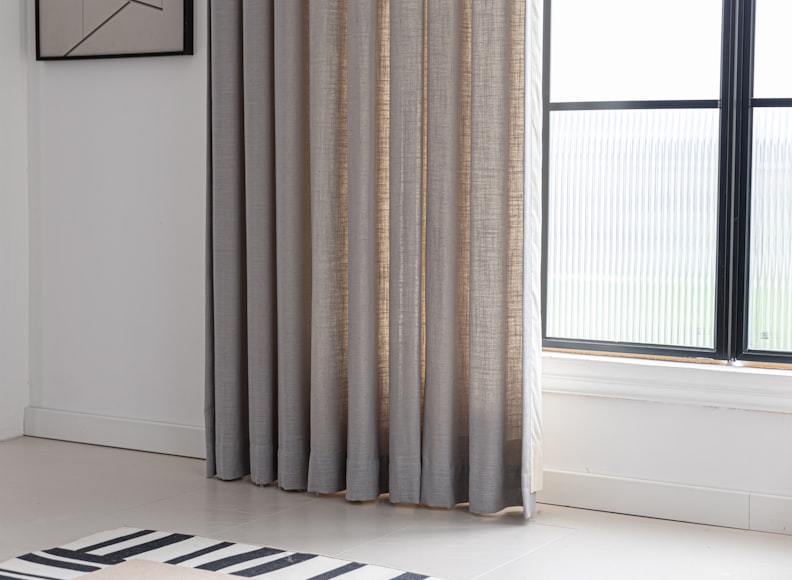 Linen curtains hung high to finish a budget bedroom window