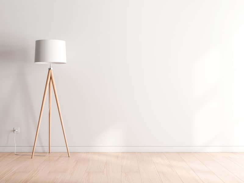 Floor lamp adding warm low light to a small bedroom corner